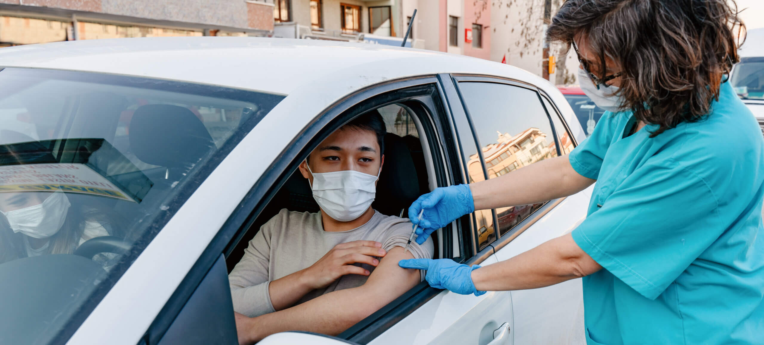 Nurse performing immunization in the car
