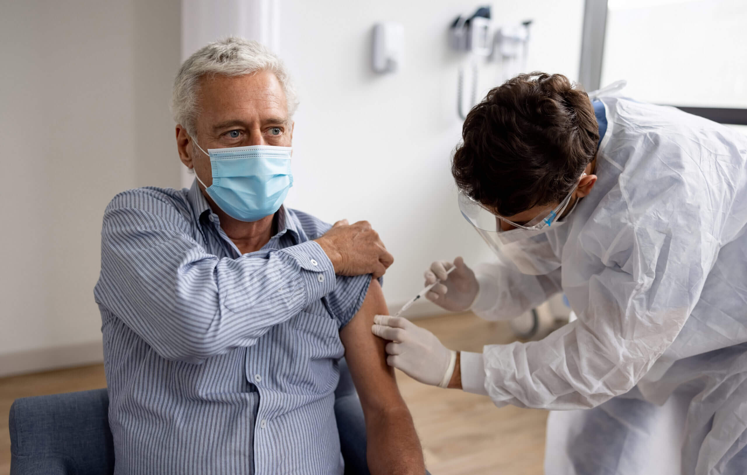 Adult man receiving COVID-19 vaccine booster.