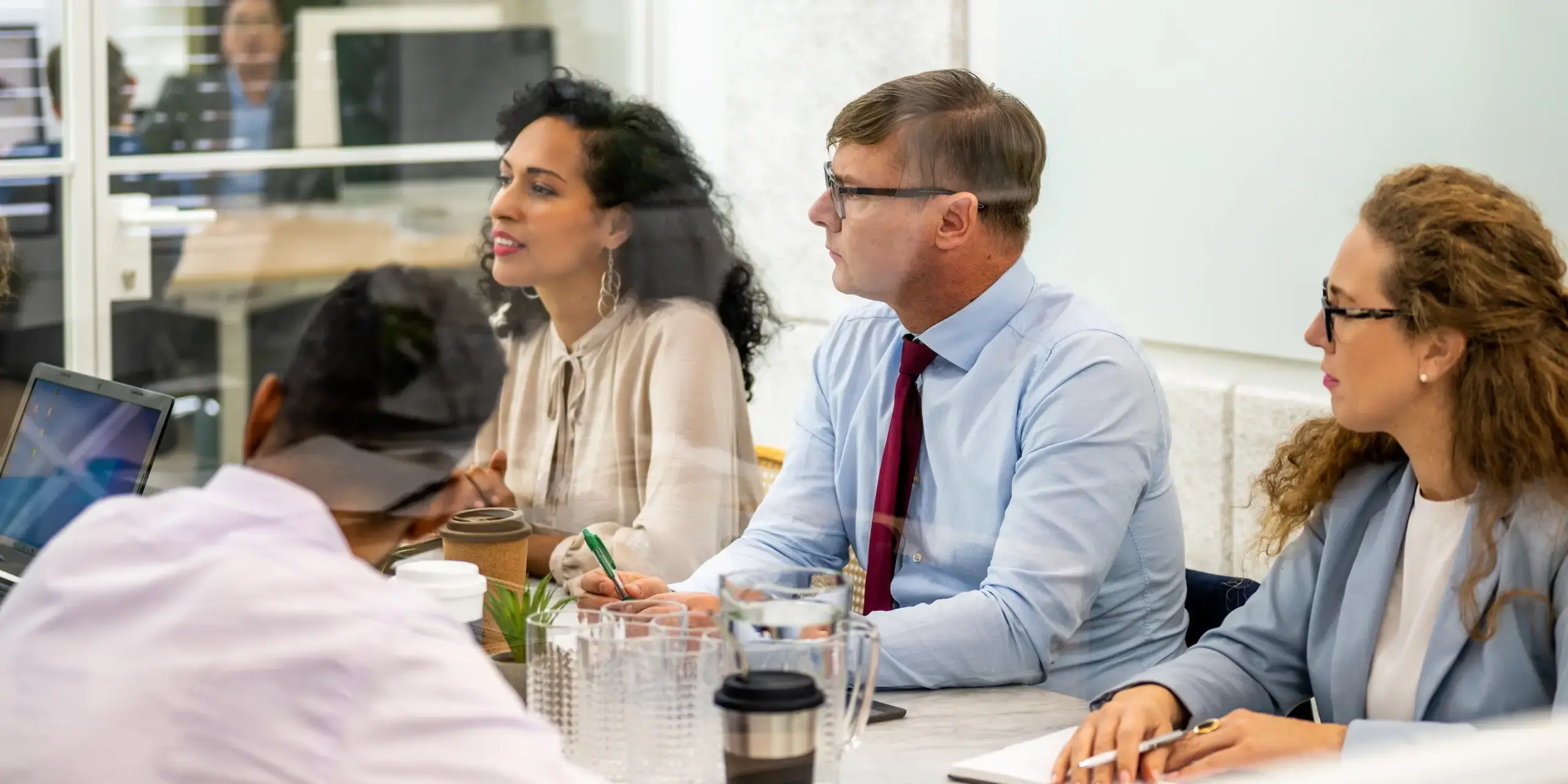 Group of business people sitting at conference table.
