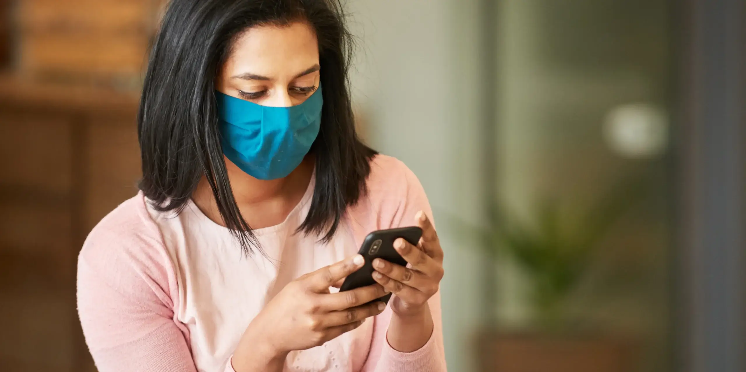 Woman with face protective mask looking at phone