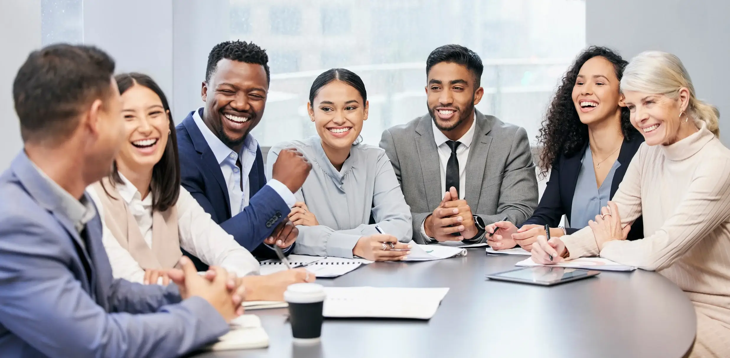 group of professionals laughing in a meeting