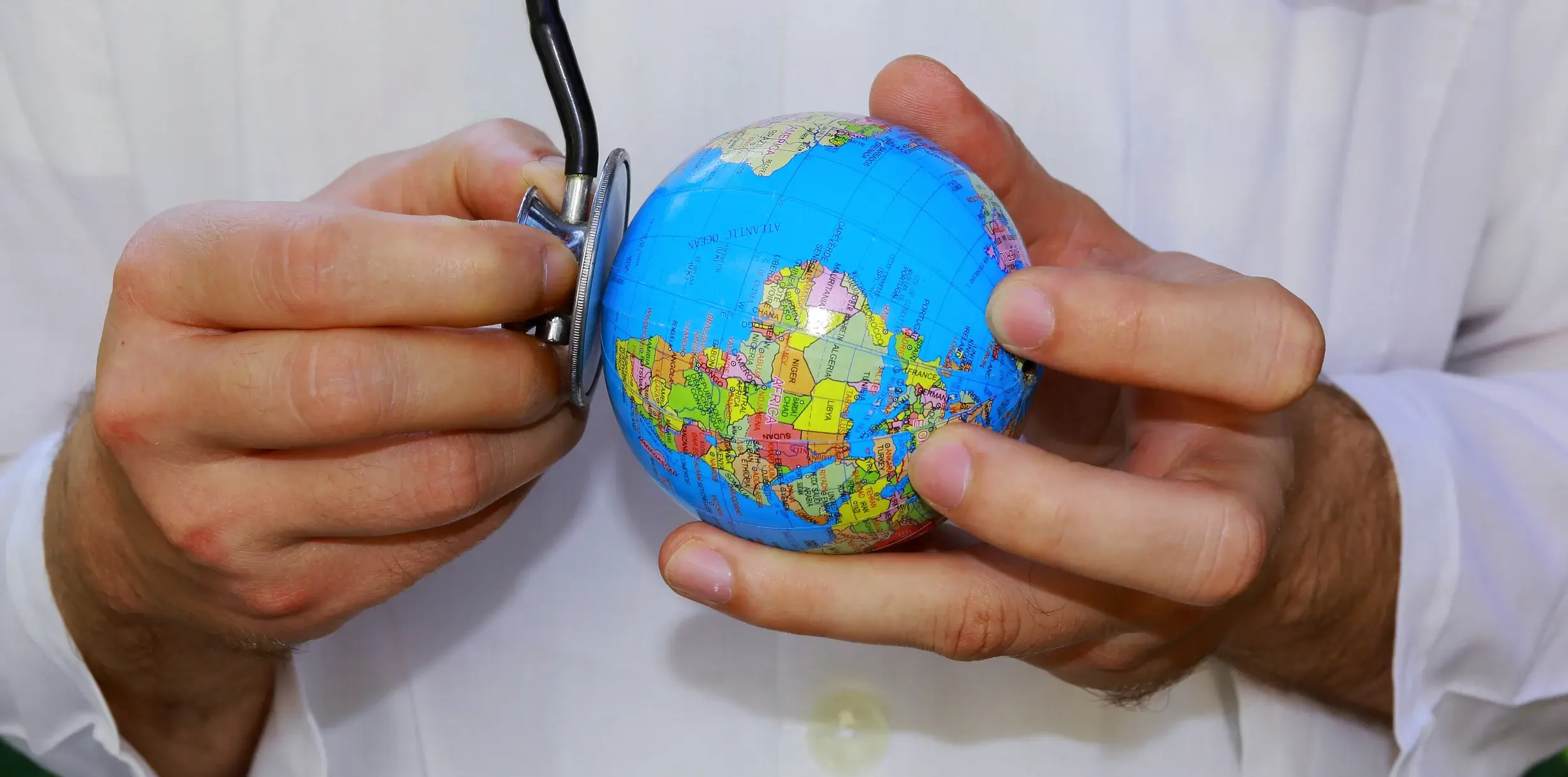 doctor examining globe as metaphor for public health crises