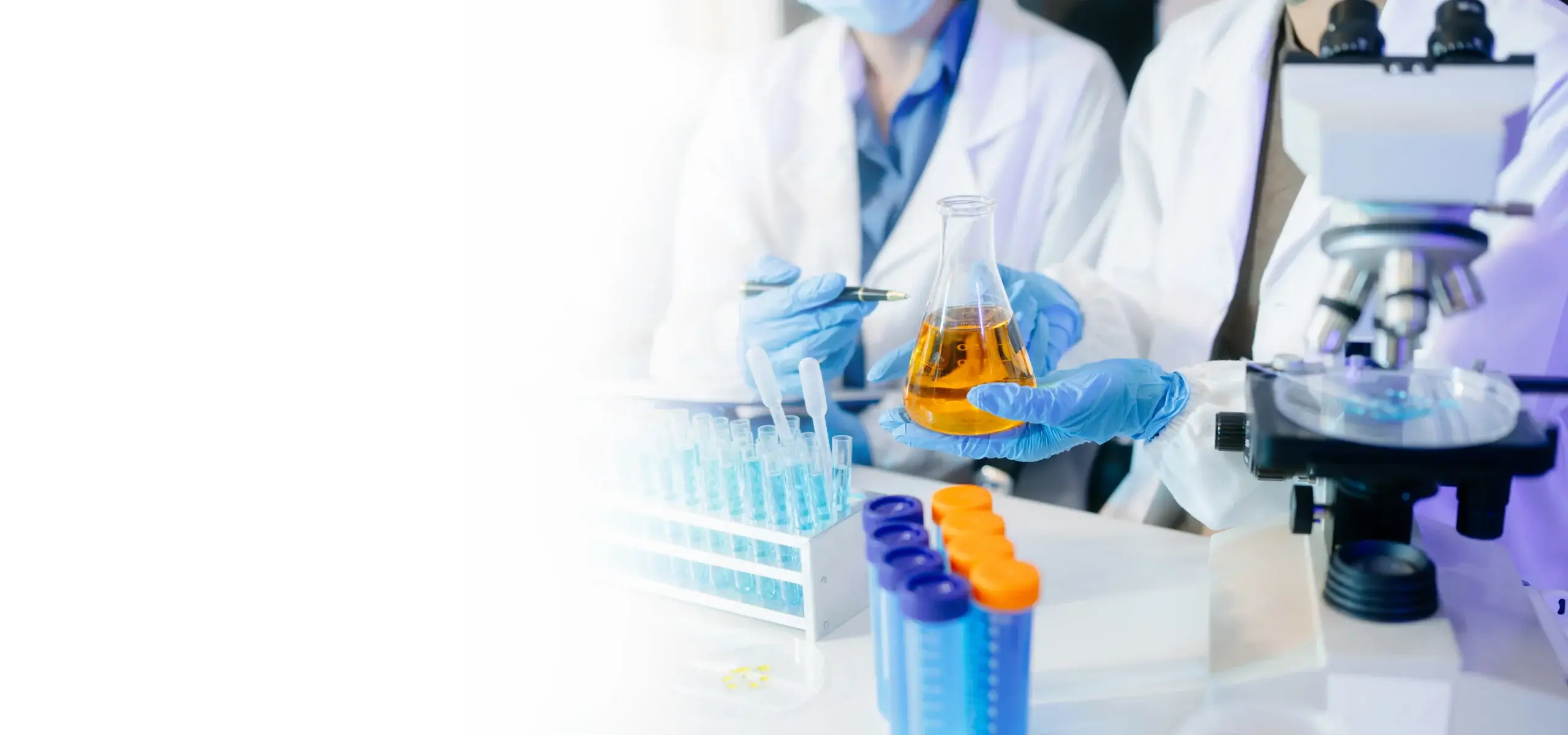 scientists in lab coats conducting research, handling glassware, and working with chemicals